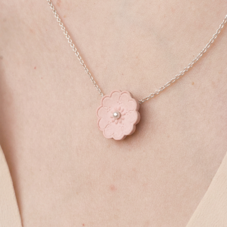 Zilveren ketting met een roze porseleinen bloemetje en een pareltje - Hester ZAgt